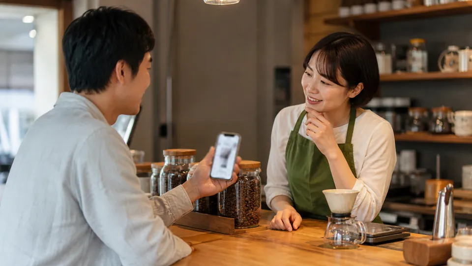 カフェのカウンターで好みのコーヒーについて相談する利用客