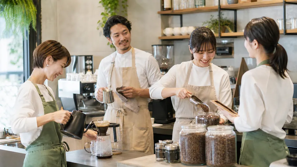 一般的なカフェで役割を分担して働く複数の店員