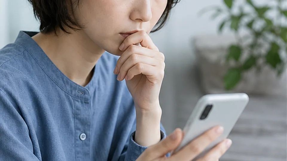Xアカウント削除後の見え方をスマートフォンで確認する女性