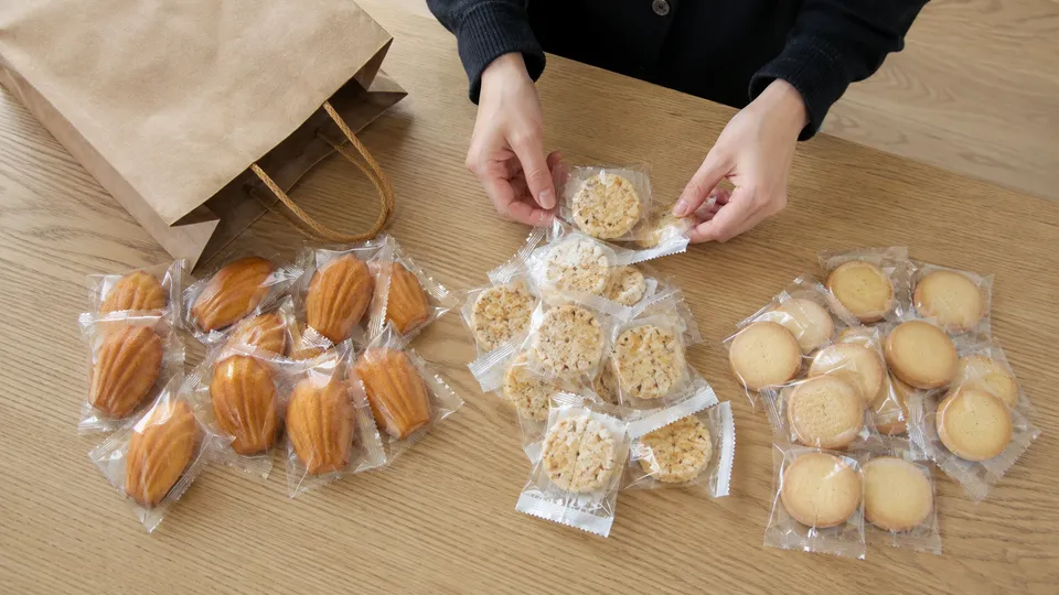 差し入れ用の個包装菓子を種類ごとに分けて数えているイメージ