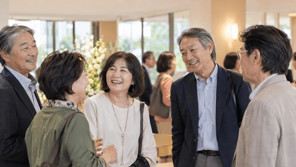 同窓会で再会し穏やかに会話する同級生たち